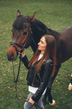 Güzel kız parkta bir at ile iletişim kurar