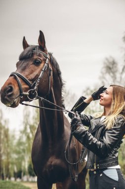 Güzel kız parkta bir at ile iletişim kurar