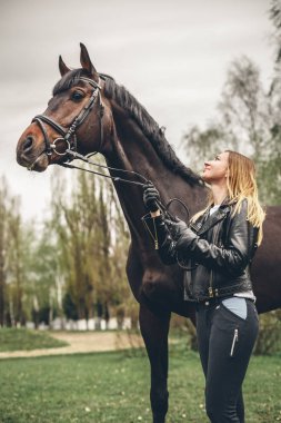 Güzel kız parkta bir at ile iletişim kurar