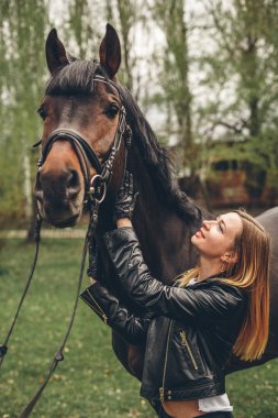 Güzel kız parkta bir at ile iletişim kurar