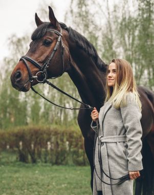 Güzel kız parkta bir at ile iletişim kurar