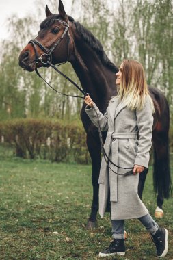 Güzel kız parkta bir at ile iletişim kurar