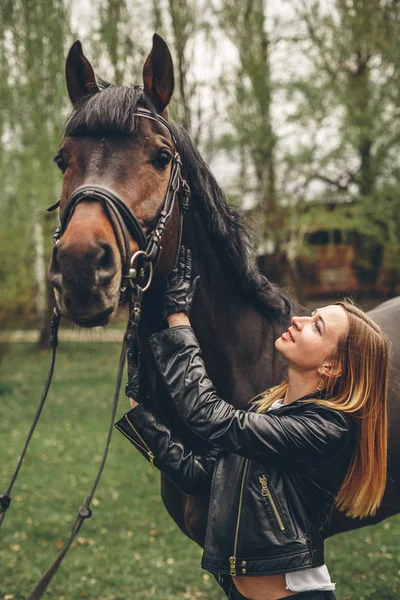 Güzel kız parkta bir at ile iletişim kurar