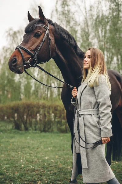 Güzel kız parkta bir at ile iletişim kurar