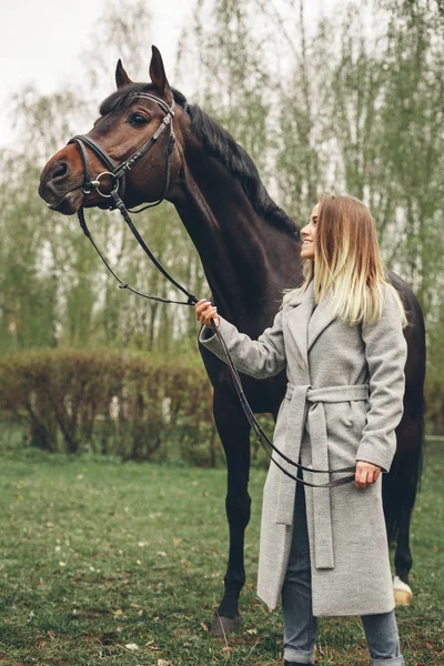 Güzel kız parkta bir at ile iletişim kurar