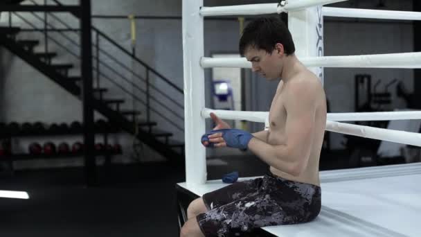 Hombre boxeador quita vendas en su mano después de la pelea — Vídeo de stock