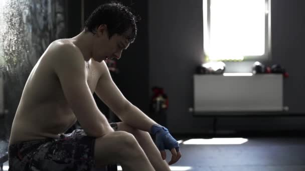 Athlete resting on the bench in the gym after training — Stock Video