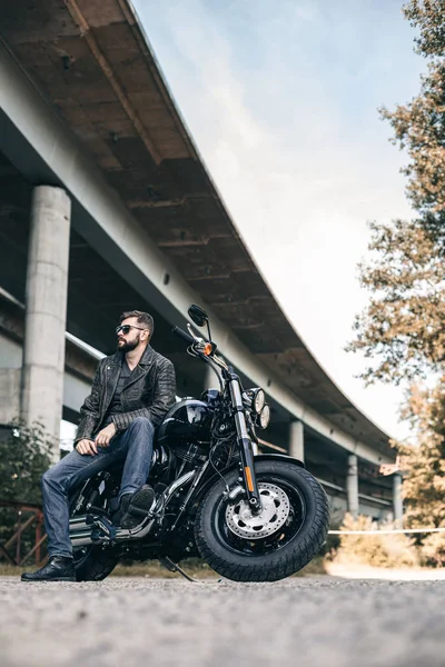 Чоловік сидить на мотоциклі на міському мосту — стокове фото
