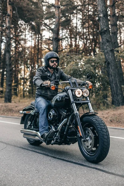 Байкер чоловік в джинсах і шкіряній куртці їде на мотоциклі — стокове фото
