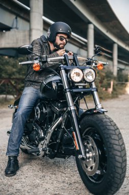 Genç acımasız adam bir siyah ceket ve motosiklet gözlükleri