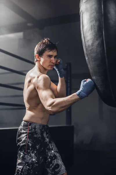 Muskulöse Kämpfer bereiten sich auf einige Tritte mit Boxsack vor — Stockfoto