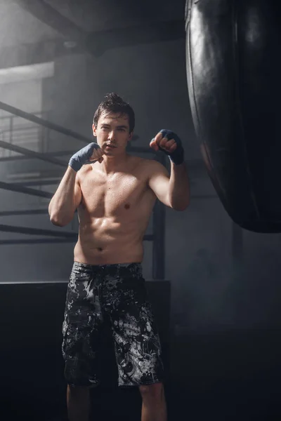 Etkin adam boks ile eğitim yumruk boks torbası için sarar — Stok fotoğraf