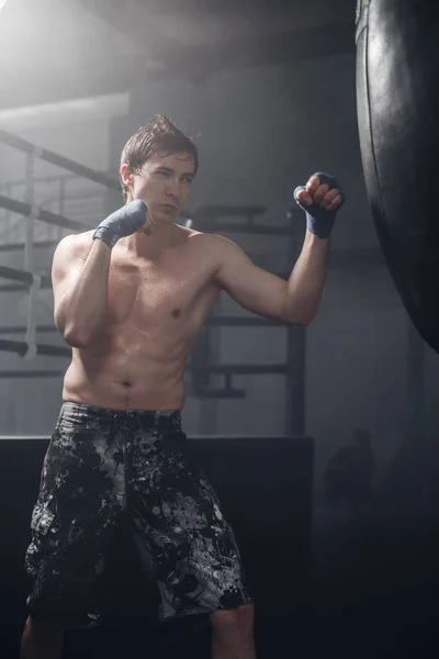 Joven haciendo entrenamiento de boxeo en el gimnasio —  Fotos de Stock