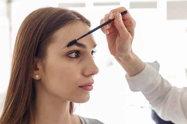 Porträtt av en vacker modell under ett förfarande för korrigering av ögonbryn — Stockfoto