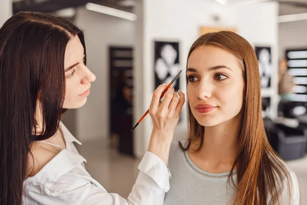 Vacker ung flicka fick korrigering av ögonbryn i en skönhetssalong. — Stockfoto