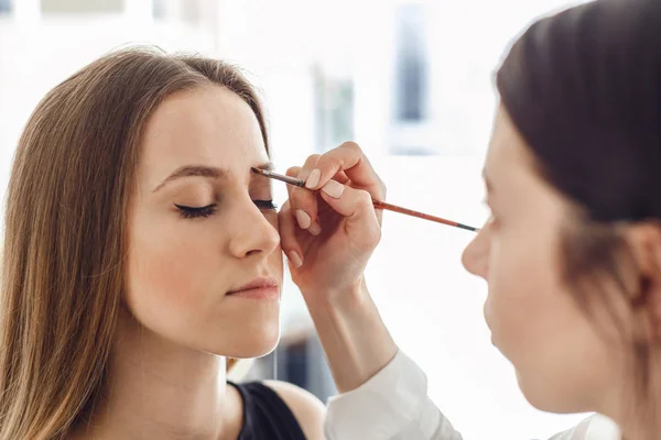 Vacker ung kvinna blir ögonbryn korrigeringsförfarandet. — Stockfoto