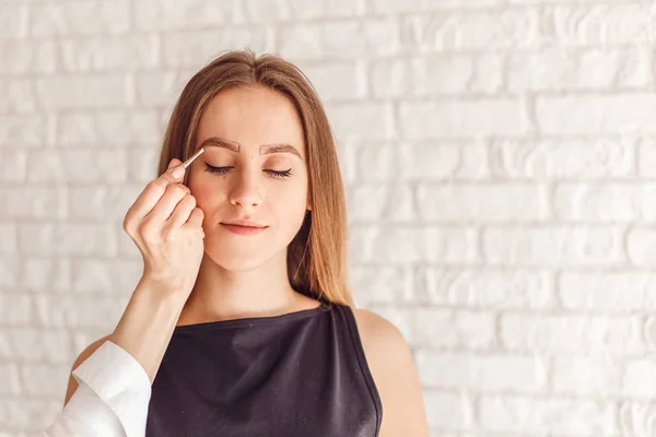 Retrato de un modelo y la mano maestra con pinzas . — Foto de Stock