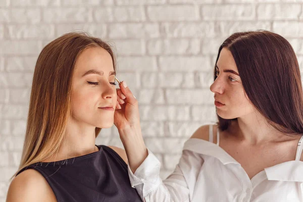 Hermosa mujer joven obtiene procedimiento de corrección de cejas . — Foto de Stock