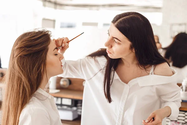 Vy över två unga kosmetolog kvinnor under smink — Stockfoto