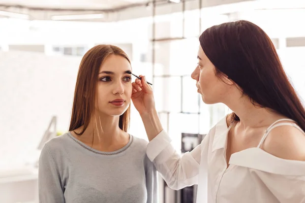 Maquiagem mestre corrige e dá forma para sobrancelhas em um salão de beleza . — Fotografia de Stock