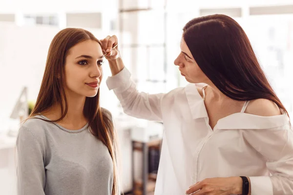 Hermosa joven consiguió corrección de cejas en un salón de belleza . — Foto de Stock