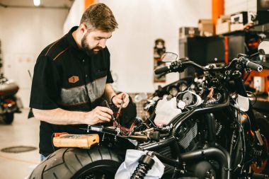 Kendine güvenen genç tamir motosiklet tamircisi adam - elektronik onarım.