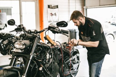 Motosiklet tamir servisinde çalışan profesyonel bir motor tamircisi..