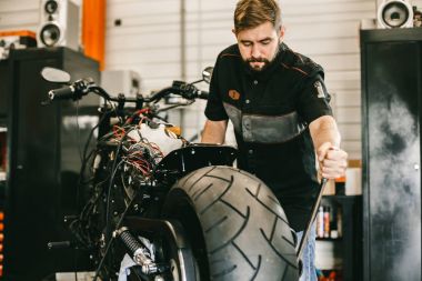Mechanician değişen motosiklet tekerlekli bisiklet tamircisi.