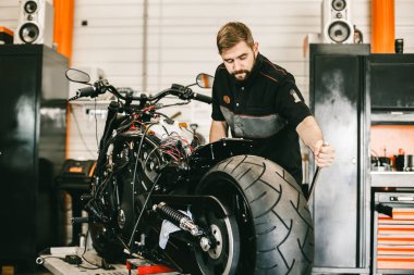 Mechanician değişen motosiklet tekerlekli bisiklet tamircisi.