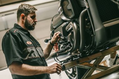Profesyonel bisiklet tamircisi motosiklet yağda düzeyini denetler.
