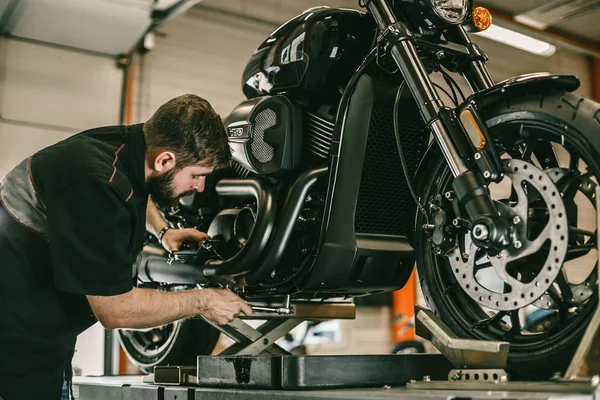 Professional mechanic change the oil in a motorcycle.