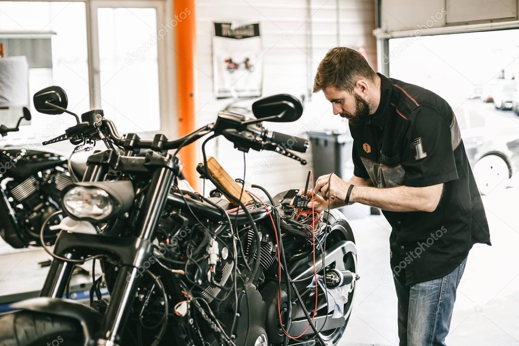Professional motorcycle mechanic working in bike repair service.