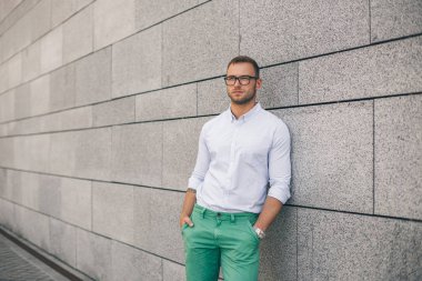 Neşeli yakışıklı delikanlı elleri ceplerinde tutmak güneş gözlüğü