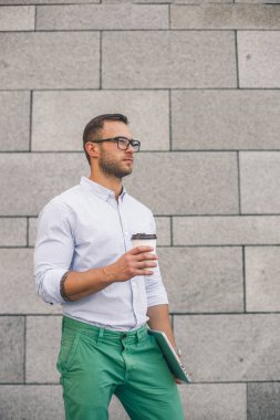 Kahve molası. Kendine güvenen genç hipster adam gözlüklü kahve fincanı holding