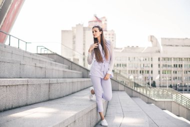 Bir şehir arka plan iş mor elbiseli güzel genç kadın