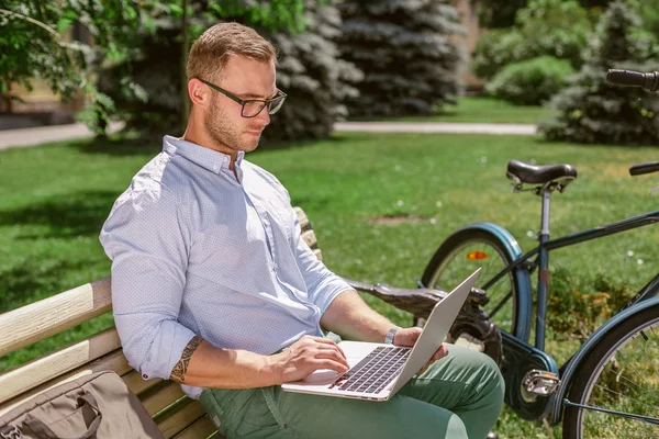 Закрытие рук бизнесмена, печатающего на ноутбуке во время перерывов на кофе в парке — стоковое фото