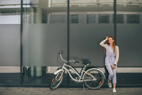 Hermosa joven sonriente mujer de pie cerca de su bicicleta vintage — Foto de Stock