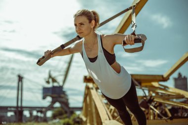 çekici genç bir kadın fitness kayışları ile süspansiyon eğitim yok