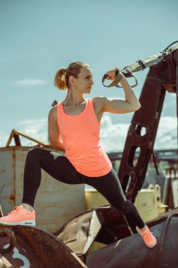 Kaslı kadın atlet itme egzersiz güneşli bir günde dışarıda yukarı