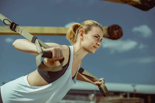 Wyświetlić zbliżenie wesoły kobieta robi push ups miejskich treningu dla broni — Zdjęcie stockowe