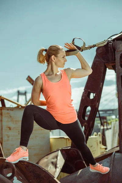 М'язиста жінка-спортсменка вправляється штовхати на вулицю в сонячний день — стокове фото