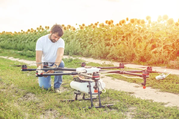 Young engineer preparing agriculture drone before flying