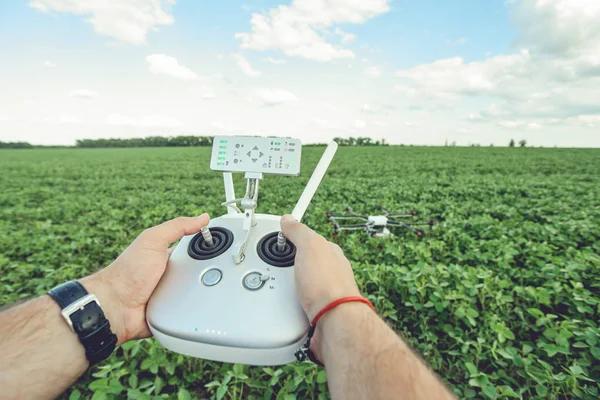 Man handen behandeling drone in zomer groen veld landschap panorama. — Stockfoto