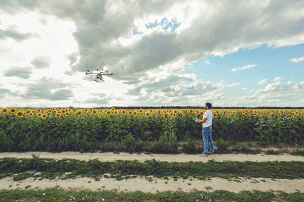 Professional drone flying with blue sky background controlled by young man