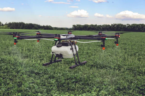 Landbouw drone vliegen naar gespoten meststof op de groene velden. — Stockfoto