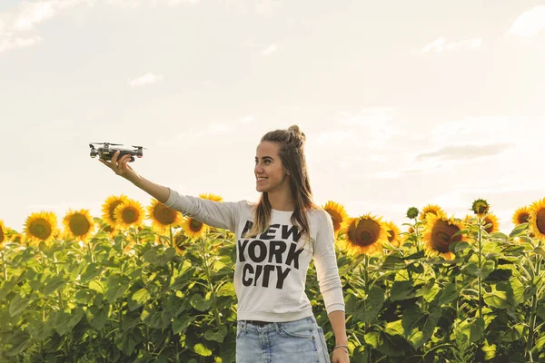 Mujer joven sosteniendo a mano vuelo mini dron al aire libre . — Foto de Stock