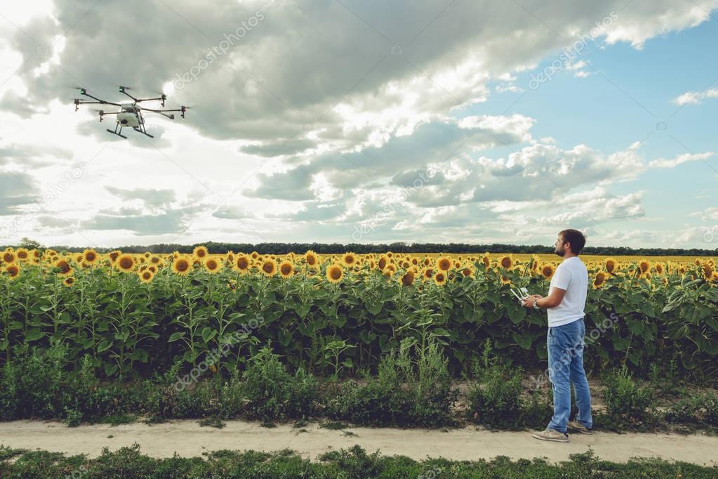 Professional drone flying with blue sky background controlled by young man