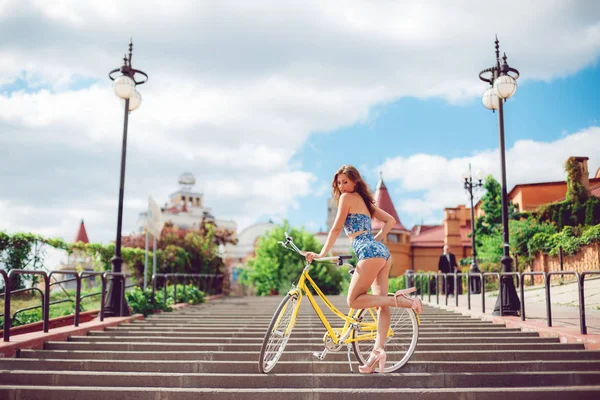 Mulher incrível posando perto de bicicleta, modelo de moda em roupas sexy . — Fotografia de Stock
