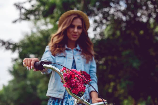 Primer plano de un timón de bicicleta y fondo borroso con una mujer joven — Foto de Stock