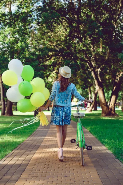 Güzel bir kadının arka görünümünden bir retro bisiklet ile gidiyor.